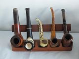 five different types of pipe holders on a wooden stand