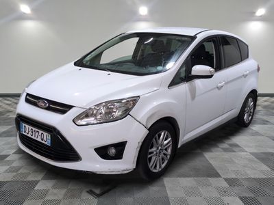 le ford c - max blanc est garé sur un sol en damier