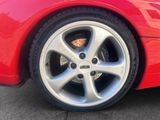 a close up of a red car ' s wheel on the street