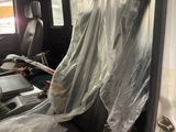 a car that is covered with plastic and sitting in the back of it