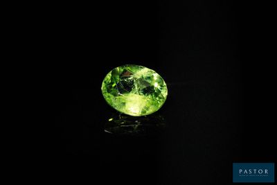 une tourmaline verte posée sur un fond noir
