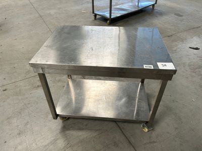 deux tables en acier inoxydable montées sur roulettes dans une zone d'entrepôt