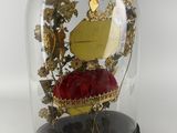 a glass dome with a gold and red object inside of it