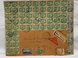 une vieille enveloppe sur laquelle sont apposés des timbres, posée sur une surface blanche
