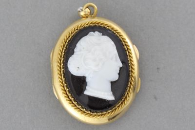 une image représentant un pendentif camée en noir et blanc représentant une tête de femme
