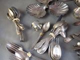 a lot of silver spoons and silverware on the table