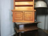 a mannequin head next to a cabinet and a table
