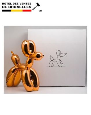 an image of a golden balloon dog sitting next to a white box