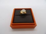 an orange box with a ring inside of it on a white surface
