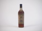 une vieille bouteille de whisky posée sur une surface blanche