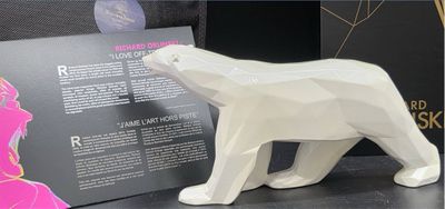 a white bear figurine on a table next to a book