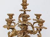 an antique brass candelabra with five candles and a black marble base