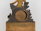 a bronze statue of a woman sitting on top of a clock