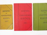 three books are lined up in a row on a white surface