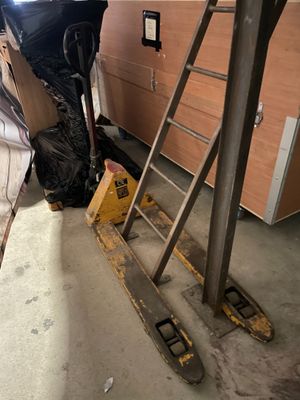 un homme debout à côté d'une échelle dans un garage