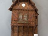 a small wooden house with a clock on the wall