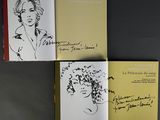 three books with drawings of a woman on them sitting on a table