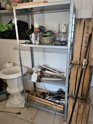 une étagère avec des outils et des toilettes dans une salle de bains