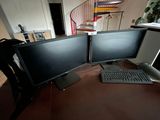 two computer monitors sitting on a desk with a keyboard and mouse