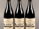 trois bouteilles de vin posées sur une table l'une à côté de l'autre