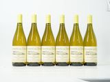 six bouteilles de vin blanc sont alignées sur une table