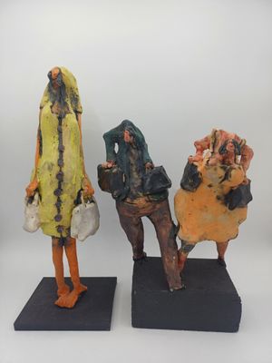 deux sculptures représentant des personnes assises sur un banc, sur fond blanc