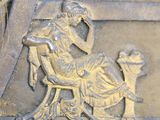 a statue of a woman sitting on a chair with a dog