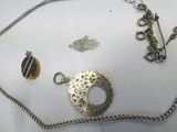 a silver necklace and a silver chain with a pendant on it