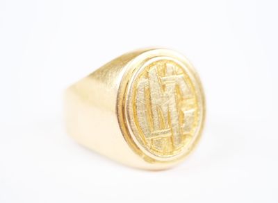 a close up of a gold signet ring on a white surface