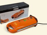 un outil électrique orange posé devant une boîte