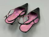 pair of black shoes with pink soles on a white surface