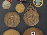 several medals are displayed on a black surface with a red cross