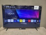 a flat screen tv sitting on top of a table next to a remote