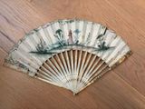 a fan that has a painting on it on a wooden floor