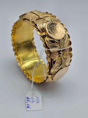 Gros plan sur un bracelet en or orné de pièces de monnaie