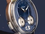 a close up of a watch on a blue surface