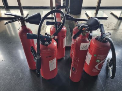 several fire extinguisors are lined up on a table