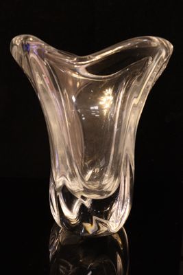 a glass vase that is sitting on a black surface