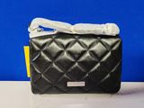 black quilted purse with a white bow on top of it