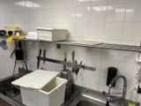 a kitchen with a sink and a lot of clutter on the counter