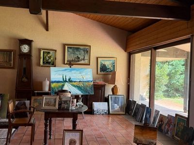 un salon avec de nombreux tableaux accrochés aux murs