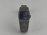 an image of a silver watch with a blue face sitting on a white surface