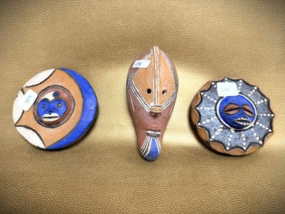 three decorative items that are sitting on a gold surface