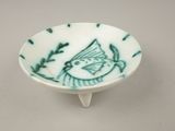 a small bowl with a bird on it on a table