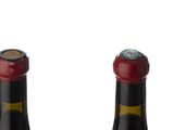 three bottles of wine are lined up in a row on a white surface