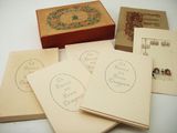 five old postcards sitting on top of each other on a table