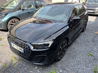 une voiture noire garée dans un parking à côté d'autres voitures