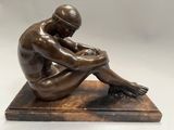 statue d'un homme assis sur un socle de marbre, les mains posées sur les genoux