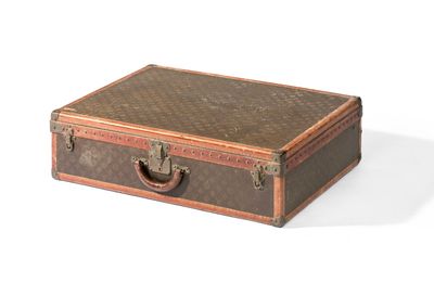 une petite valise marron munie d'une poignée, posée sur une surface blanche