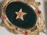 a gold brooch with a star in the middle of it